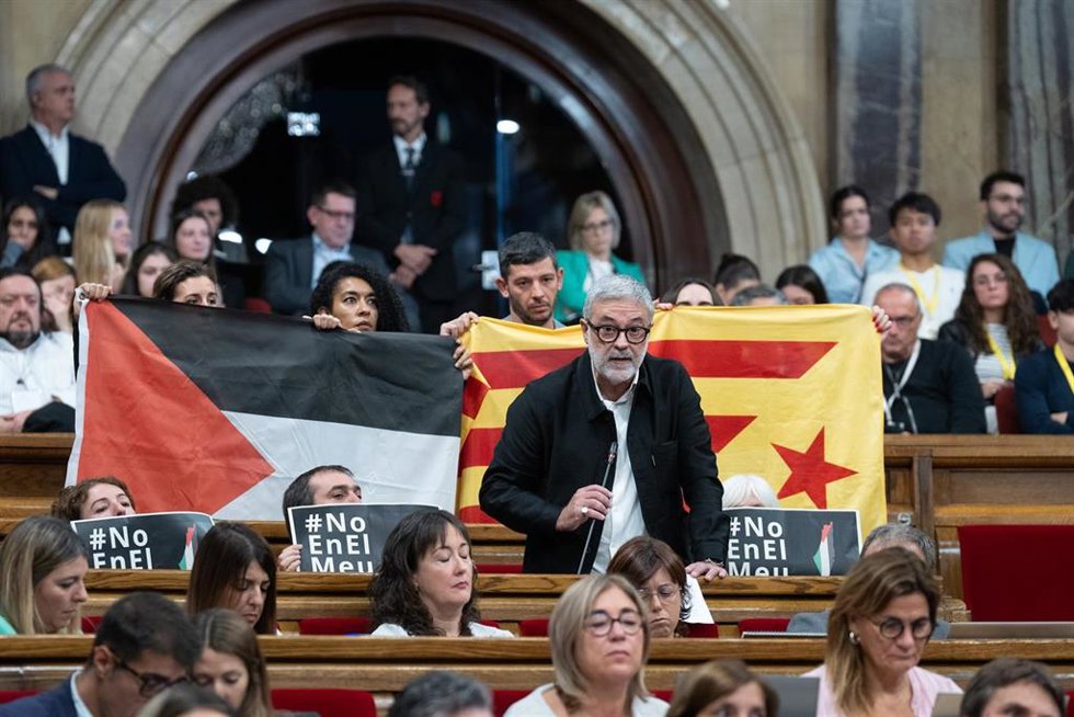 Los diputados de la CUP despliegan una bandera palestina y una 'estelada' durante la intervención del 'cupaire' Carles Riera en la sesión de control al Govern en el Parlament