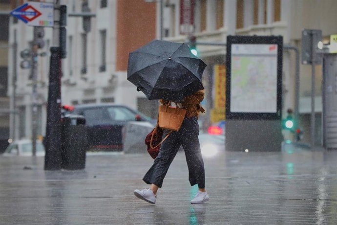 Archivo - Una persona camina por el centro de la capital en una jornada marcada por las lluvias y la bajada de temperaturas, en Madrid, (España), a 2 de octubre de 2020. Esto se debe a la llegada de la borrasca atlántica Alex que se profundiza desde aye