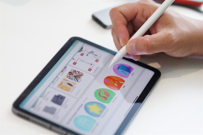 Archivo - Una persona mira a través de una tablet la web de Amazon, en Madrid (España). 