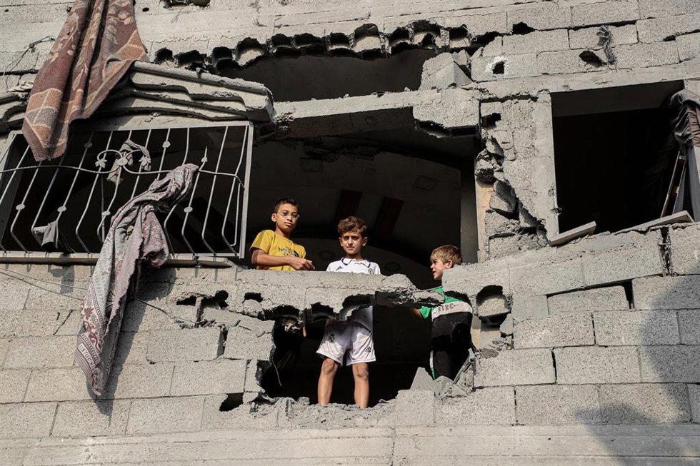 Unos niños se asoman en un edificio destruido en la Franja de Gaza