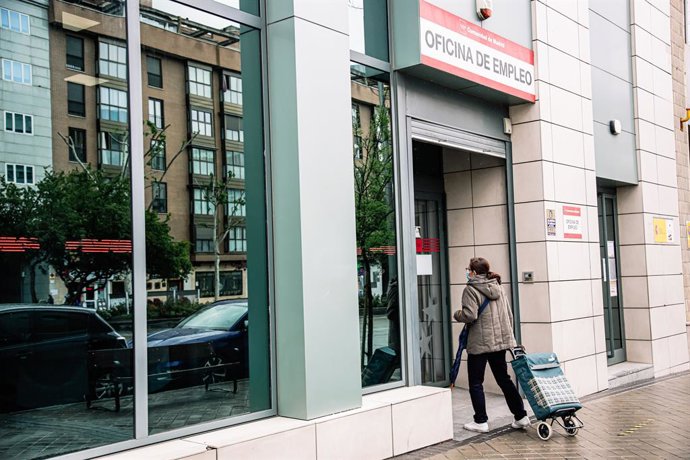 Archivo - Una mujer entra en una oficina de empleo