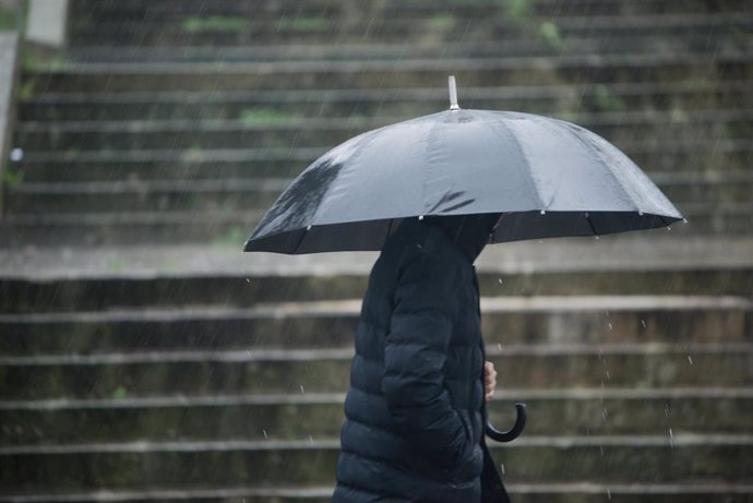 Archivo - Arquivo - Unha persona con paraugas para protexerse da choiva camiña pola Rua Loureiro Crespo, a 16 de xaneiro de 2023, en Pontevedra, Galicia (España).  A borrasca Gérard, sétima da temporada, adiántase á borrasca Fien e afectou hoxe a Esp