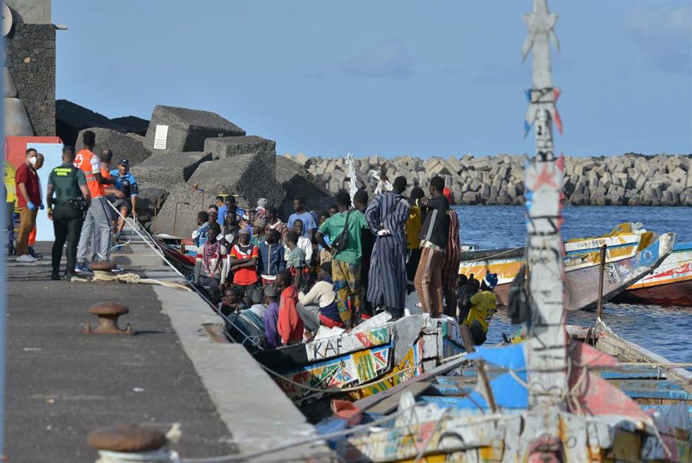 Trabajadores de la Cruz Roja y agentes de la Guardia Civil al lado de uno de los cayucos que ha llegado al puerto de La Restinga, a 23 de octubre de 2023, en El Hierro.