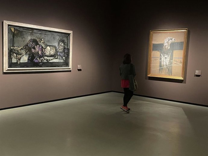 El MNAC explora la figura humana en el arte de posguerra en una exposición. Una visitante ante la obra 'Fragmento de una crucifixión' de Francis Bacon