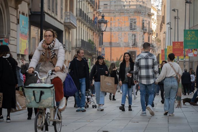 Archivo - Diverses persones en un carrer comercial