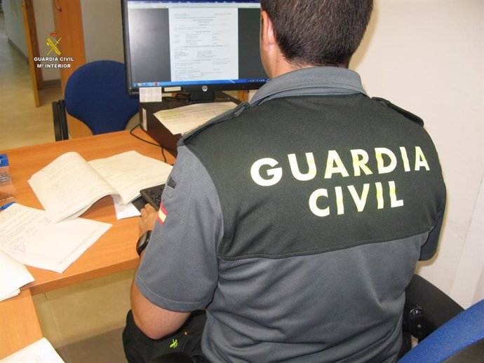 Archivo - Guardia civil durante estudio de documentación