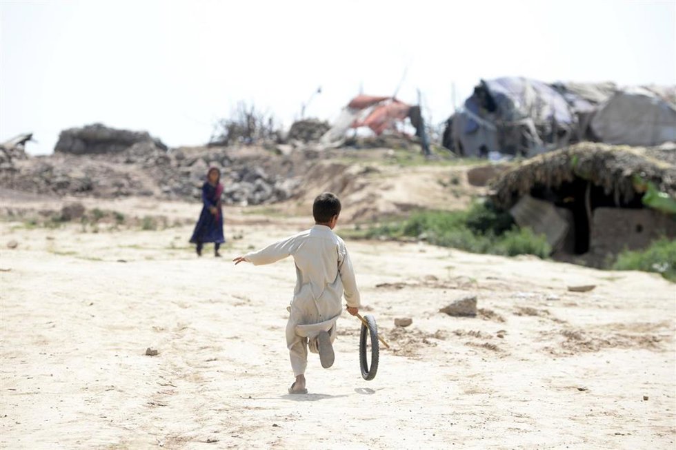 Archivo - Dos niños juegan en un campo de refugiados en Islamabad