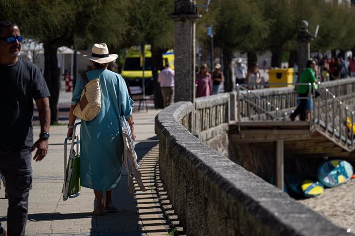 Una mujer se dirige a la playa Silgar, a 30 de septiembre de 2023, en Sanxenxo, Pontevedra, Galicia.