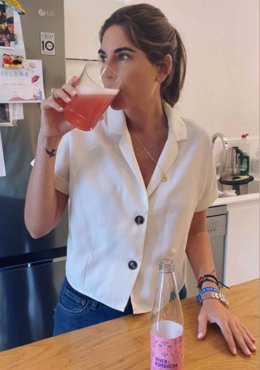 Imagen de Lourdes Montes bebiendo un vaso de kombucha de la marca Víver Kombucha.