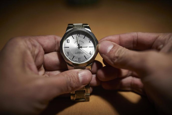 Archivo - Un hombre cambia las manecillas de un reloj a las 3 horas, en Madrid (España)