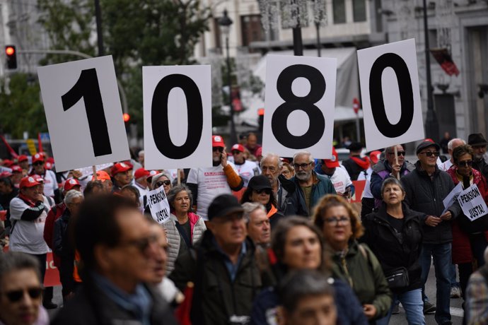 Decenas de personas portan carteles y banderas durante una concentración de pensionistas, desde Atocha a Sol, a 28 de octubre de 2023, en Madrid (España). 