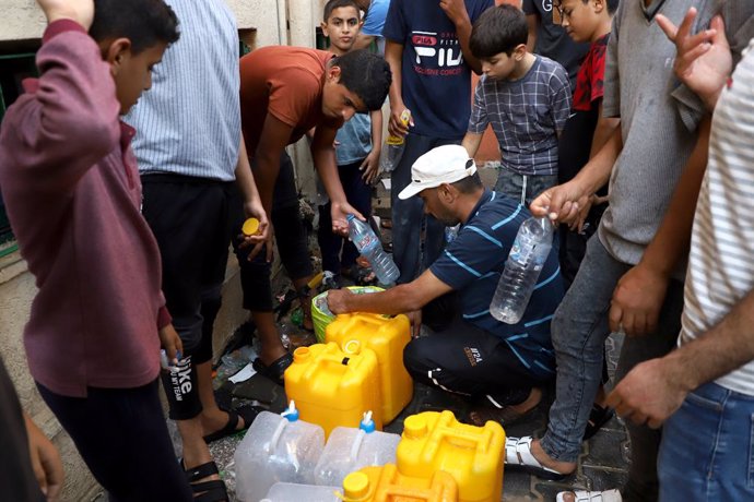 GAZA, Oct. 27, 2023  -- People fetch water in the southern Gaza Strip city of Khan Younis, on Oct. 26, 2023. The Palestinian Islamic Resistance Movement (Hamas) launched a surprise attack on Israel on Oct. 7, firing thousands of rockets and infiltrating