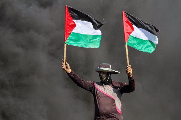 Archivo - Imagen de archivo de palestinos ondeando la bandera de Palestina durante una protesta