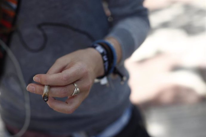 Archivo - Mujer fumando un cigarro de liar.