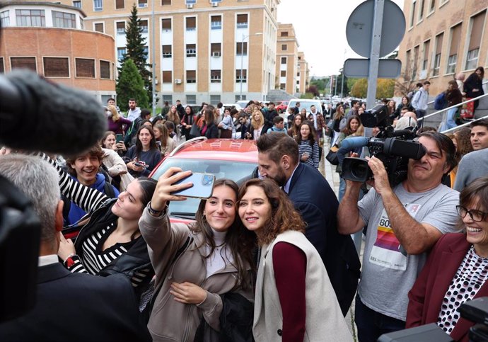 La presidenta de la Comunidad de Madrid, Isabel Díaz Ayuso, se fotografía con una alumna de la Complutense durante una visita a esta institución académica.