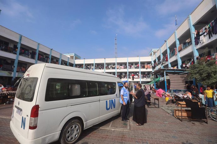 October 25, 2023, Gaza, ISRAEL, Palestine: A man speaks with a worker of the United Nations Relief and Works Agency for Palestine Refugees (UNRWA) agency outside one of their vehicles parked in the playground of an UNRWA-run school that has been convert