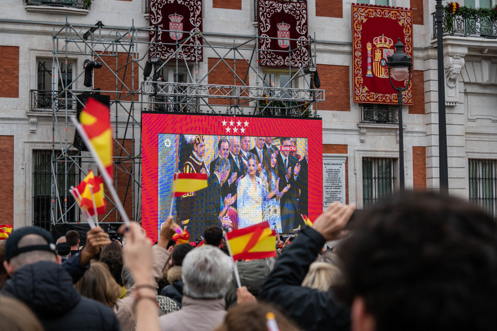 Varias personas siguen en pantallas, preparadas para la ocasión, el Juramento de la Constitución de la Princesa Leonor, en la Puerta del Sol, a 31 de octubre de 2023, en Madrid (España). 