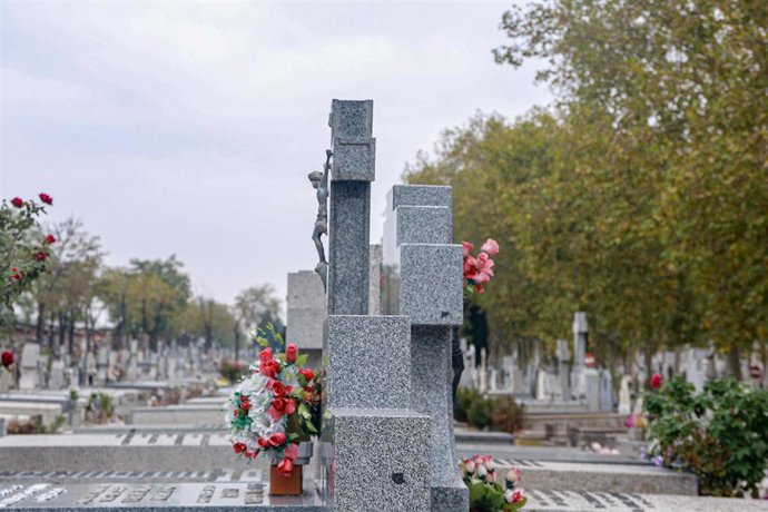 Archivo - Varias lápidas con flores en el Cementerio de La Almudena de Madrid.