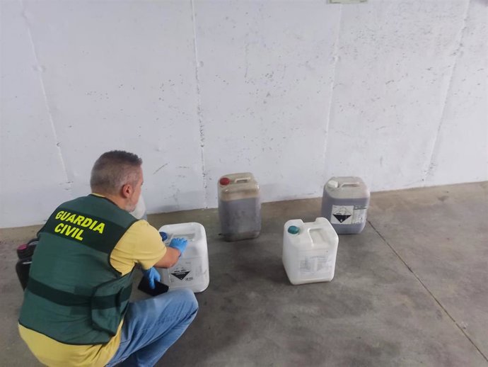 Agente de la Guardia Civil con garrafas de gasoil robado.