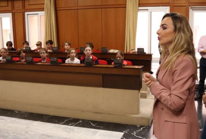 La delegada de Educación del Ayuntamiento de Córdoba, Narci Ruiz, con un grupo de cuarto curso de Primaria del Colegio Esclavas del Sagrado Corazón en el salón de plenos.