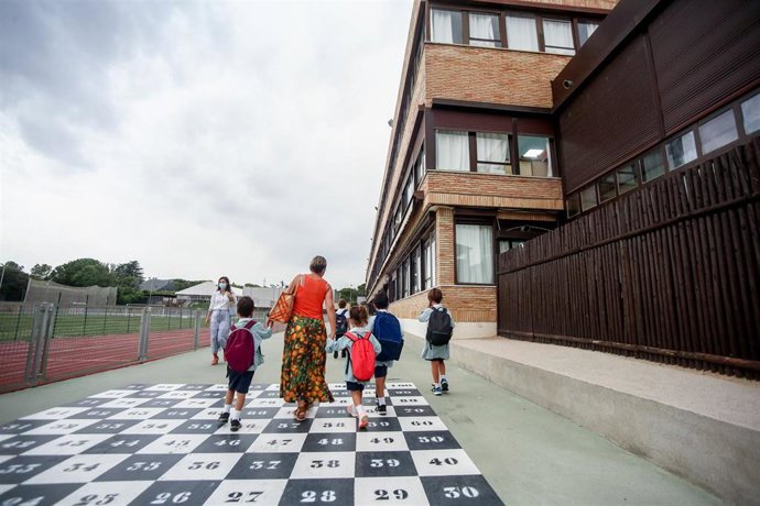 Archivo - Una madre acompaña a sus hijos a la entrada del colegio