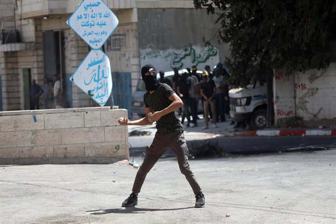 Archivo - Manifestantes palestinos tiran piedras al Ejército israelí en Hebrón, Cisjordania