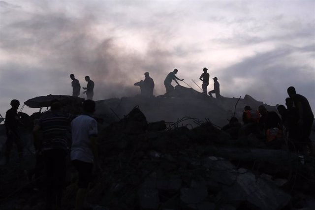 Palestinos llevando a cabo tareas de rescate en los escombros de los edificios en la Franja de Gaza
