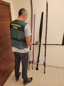 Un agente junto a las cañas de pescar sustraídas del vehículo.