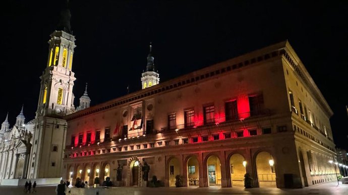 El Ayuntamiento de Zaragoza iluminado de rojo y amarillo por la Jura de la Constitución de la Princesa Leonor.