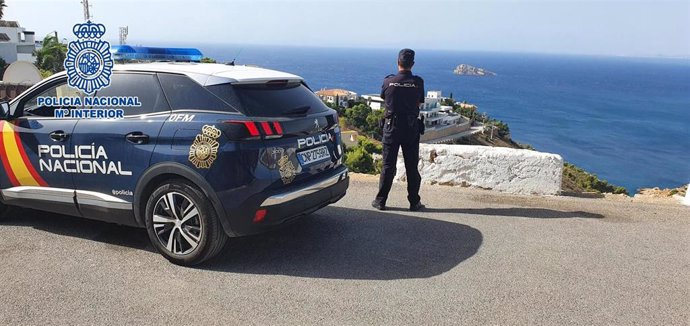 Un coche y un agente de la Policía Nacional, en imagen de archivo