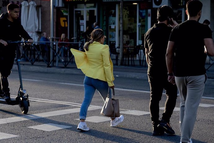 Chica (c) cruza una calle, a 17 de octubre de 2023, en Madrid (España). 