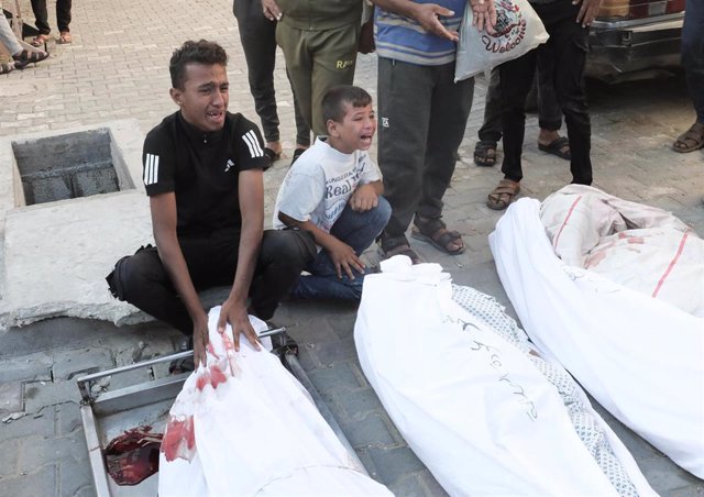 Dos niños lloran a sus familiares muertos por un ataque israelí en Gaza.
