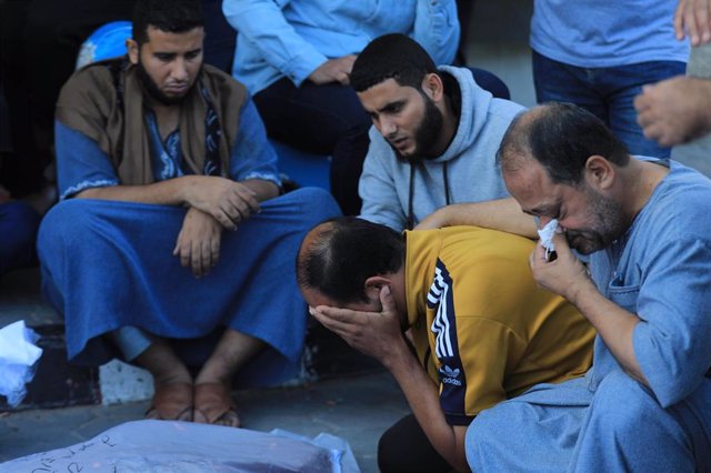 Un grupo de personas llora la muerte de sus familiares en una morgue de Gaza.