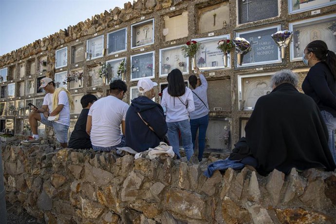 Archivo - Una mujer limpia un nicho en el cementerio de Montjuc con motivo del Día de Todos los Santos