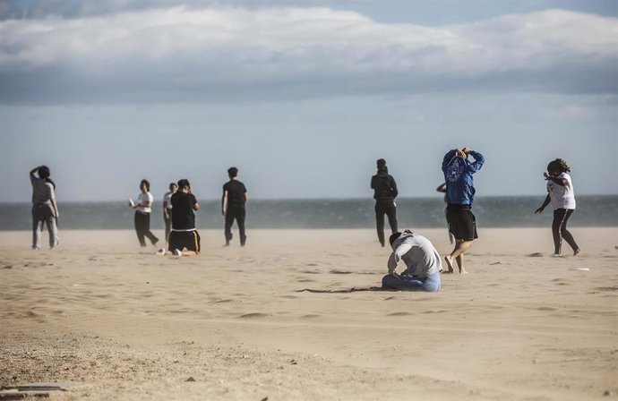 Varias personas en la playa de la Malvarrosa con fuertes rachas de viento, a 2 de noviembre de 2023, en Valencia. 