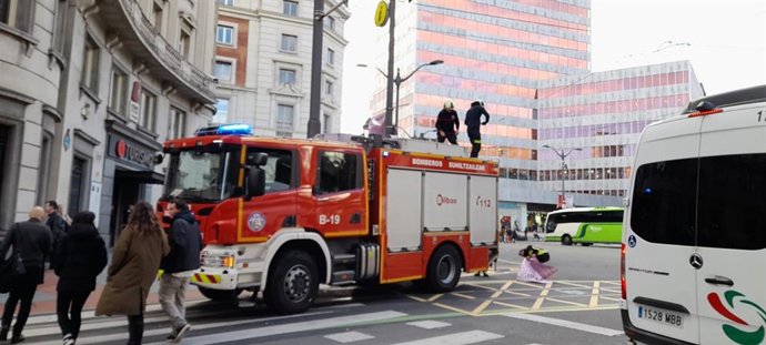 Los bomberos de Bilbao retiran unos carteles colocados en farolas por riesgo de caída por el viento.