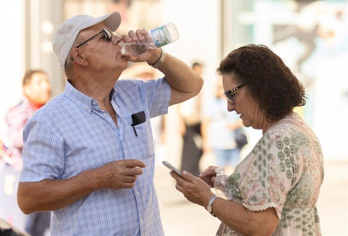 Una persona bebe agua para refrescarse 