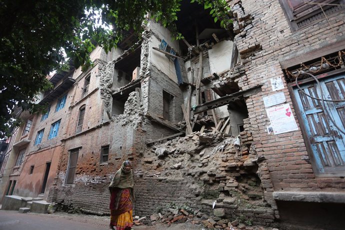 Archivo - BHAKTAPUR, Jan. 16, 2020  A woman walks past a damaged house affected by 2015 earthquake in Bhaktapur, Nepal, Jan. 16, 2020. Nepal marked the 22nd Earthquake Safety Day on Thursday, in commemoration of the devastation caused by 1934 Nepal-Bihar 