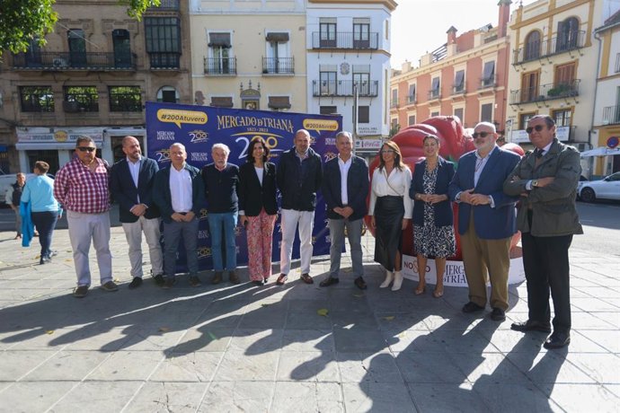 El alcalde de Sevilla, José Luis Sanz, posa con varios comerciantes del Mercado de Triana en la Plaza del Altozano.