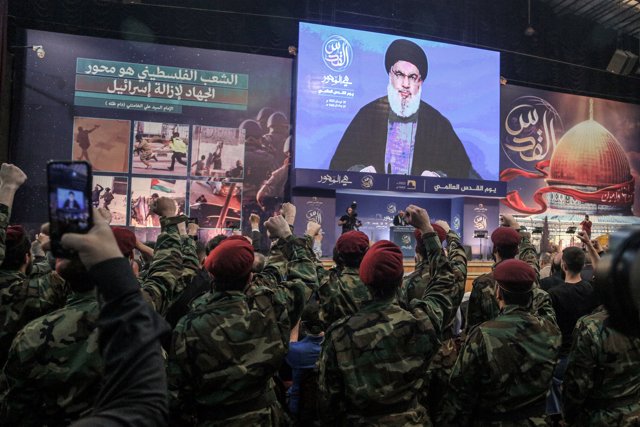 29 April 2022, Lebanon, Beirut: Pro-Iranian Hezbollah militants raise their fists to salute
