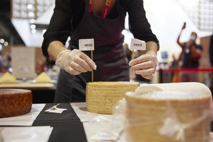 Archivo - Una persona prepara queso en la XXXIV edición del Salón Gourmets en IFEMA.