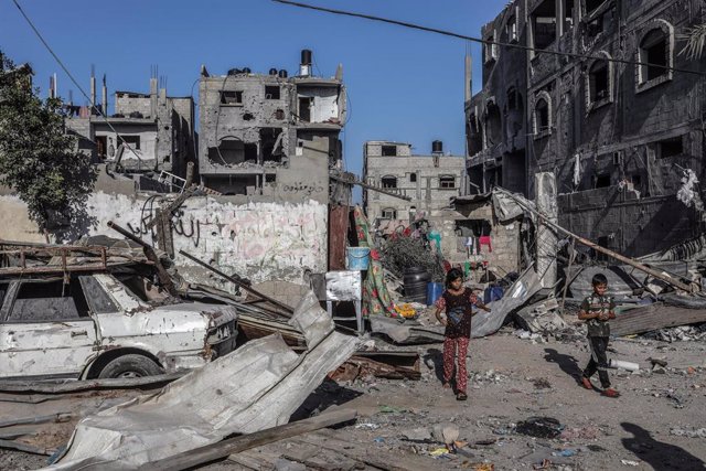 Niños palestinos frente a varias viviendas destruidas por los bombardeos de Israel contra la Franja de Gaza