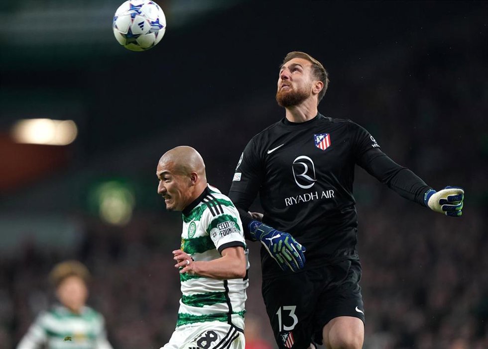 25 October 2023, United Kingdom, Glasgow: Celtic's Daizen Maeda and Atletico Madrid goalkeeper Jan Oblak battle for the ball during the UEFA Champions League Group E soccer match between Celtic FC and Atletico Madrid at Celtic Park. Photo: Andrew Millig