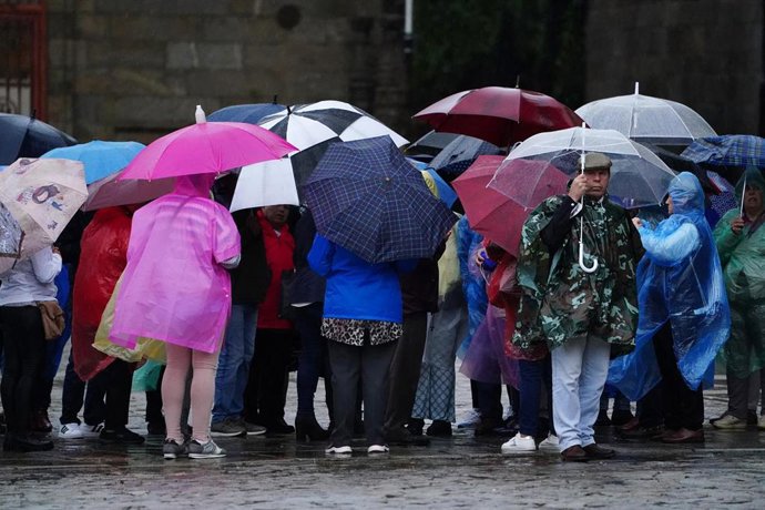 Un grupo de personas con paraguas durante el paso de la borrasca Aline, a 19 de octubre de 2023, en Santiago de Compostela, A Coruña, Galicia (España). La borrasca Aline, la primera considerada de impacto de esta temporada, se ha hecho notar en Santia