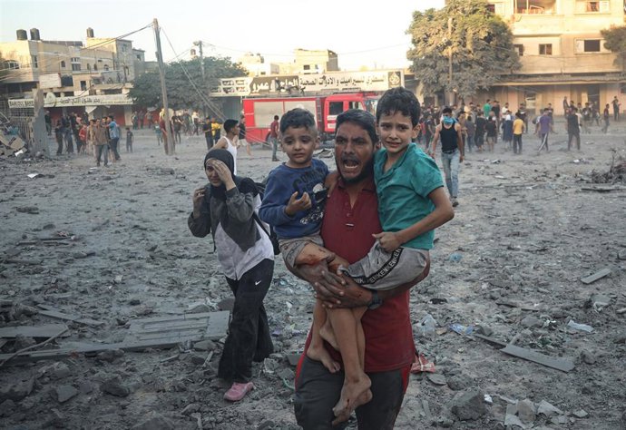 November 6, 2023, Rafah, West Bank, Palestinian Territory: A man holds two children as Palestinians flee the area near the site of a strike in Rafah on the southern Gaza Strip, amid the ongoing battles between Isreal and the militant group Hamas