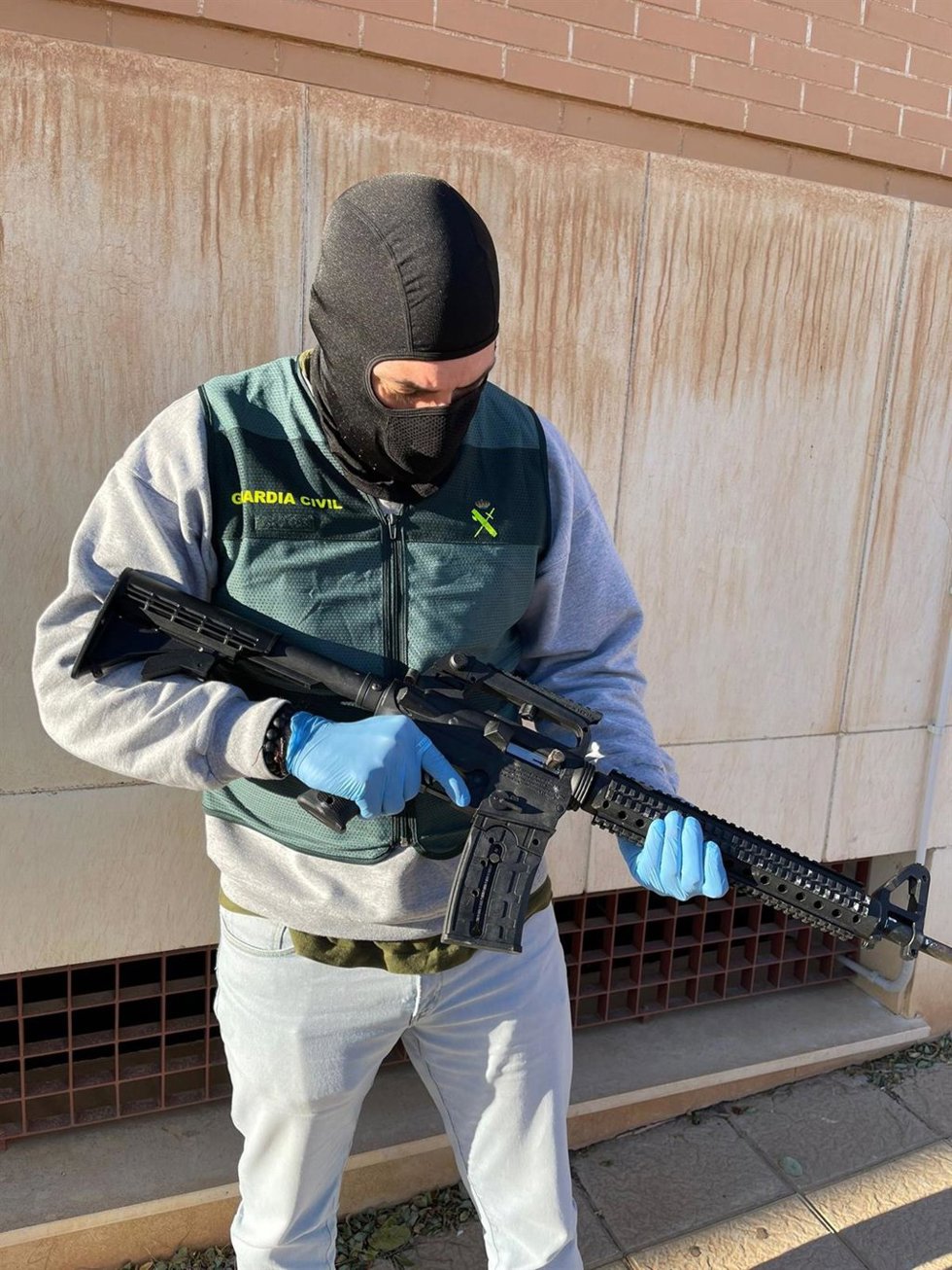 Agente de la Guardia Civil un rifle incautado.