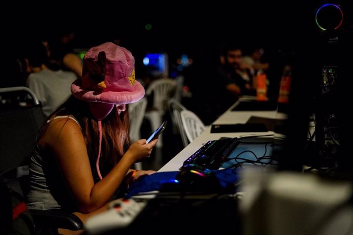 Archivo - Una joven usa un teléfono móvil durante la inauguración del festival DreamHack Valencia 2023, en la Feria Valencia, a 7 de julio de 2023, en Valencia, Comunidad Valenciana (España). DreamHack Valencia, el mayor festival de videojuegos y ocio d