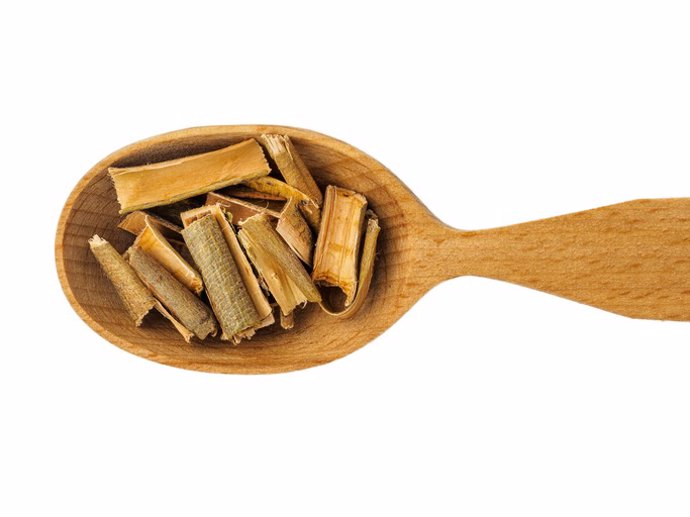 Archivo - Corteza de sauce seco en cuchara de madera sobre fondo blanco