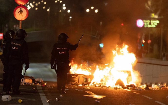 Dos policías frente a una barricada de los manifestantes concentrados en la sede del PSOE en la calle Ferraz de Madrid, a 7 de noviembre de 2023