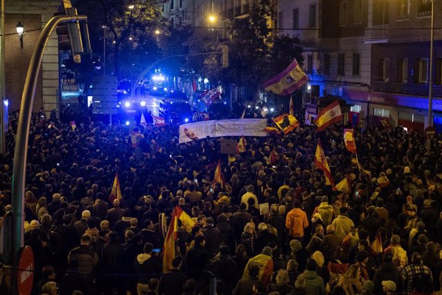 Cientos de personas con banderas y pancartas, durante una concentración en contra de la amnistía, en la sede del PSOE en la calle Ferraz 